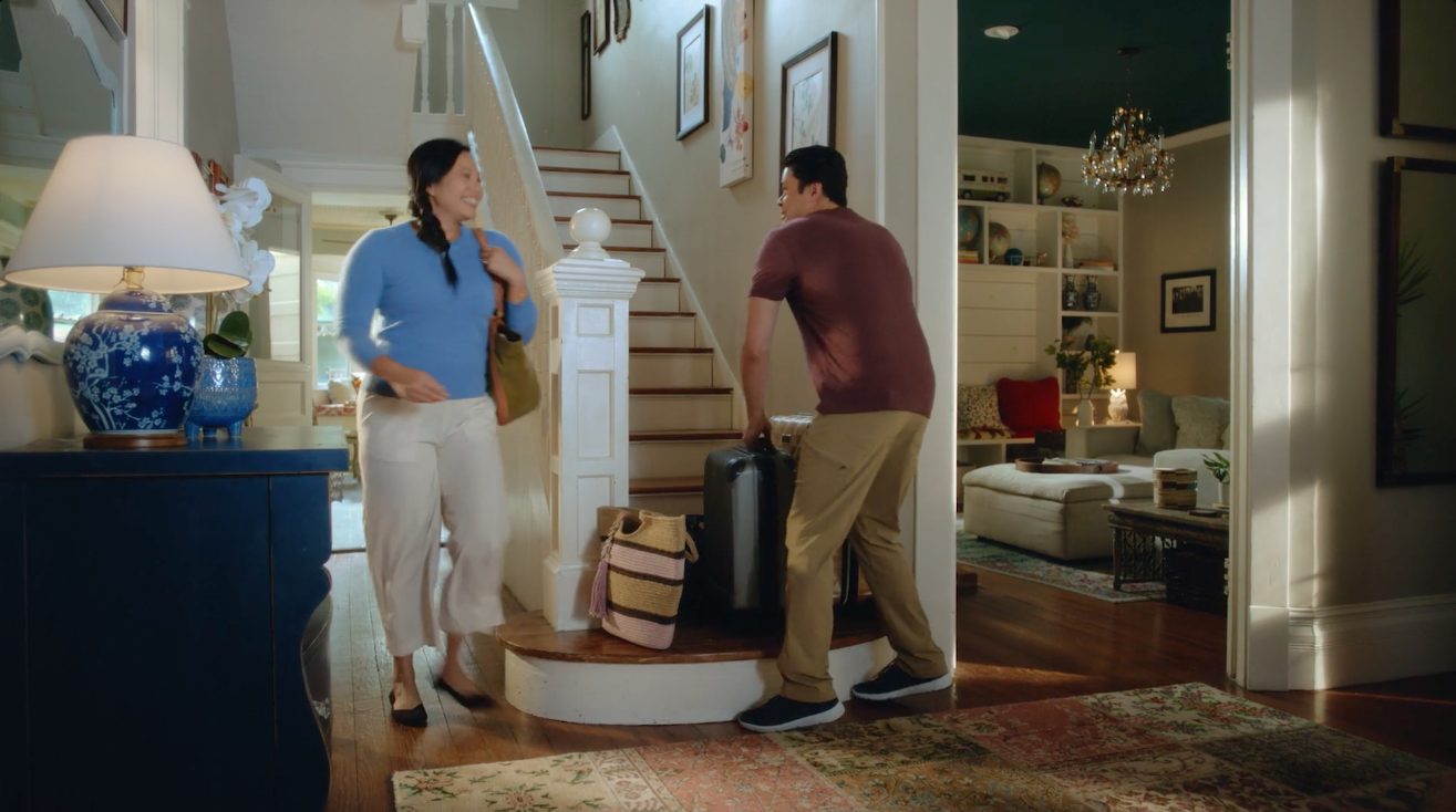 A couple coming in the front door with bags