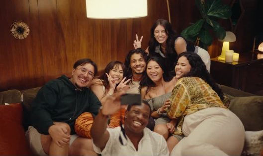 A small group piled on a couch taking a selfie
