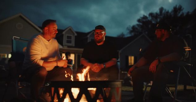 Men talking around a backyard fire